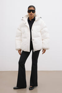 Frontalansicht der milchbeigen Damen-Oversize-Jacke mit Kapuze, kombiniert mit schwarzer Hose im urbanen Look 