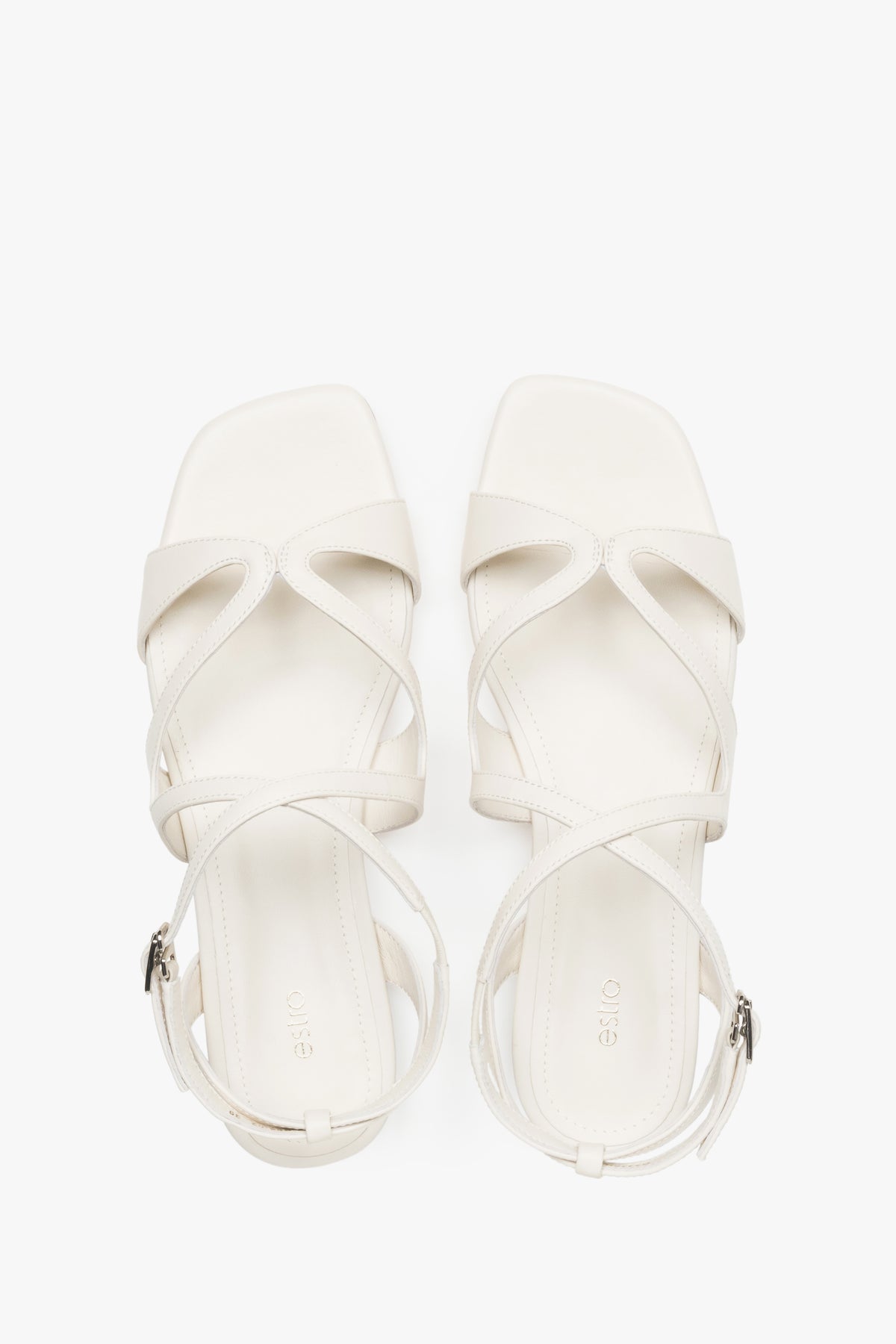 Draufsicht auf das Paar milchbeiger Damen-Sandalen mit Schnallenverschluss.
