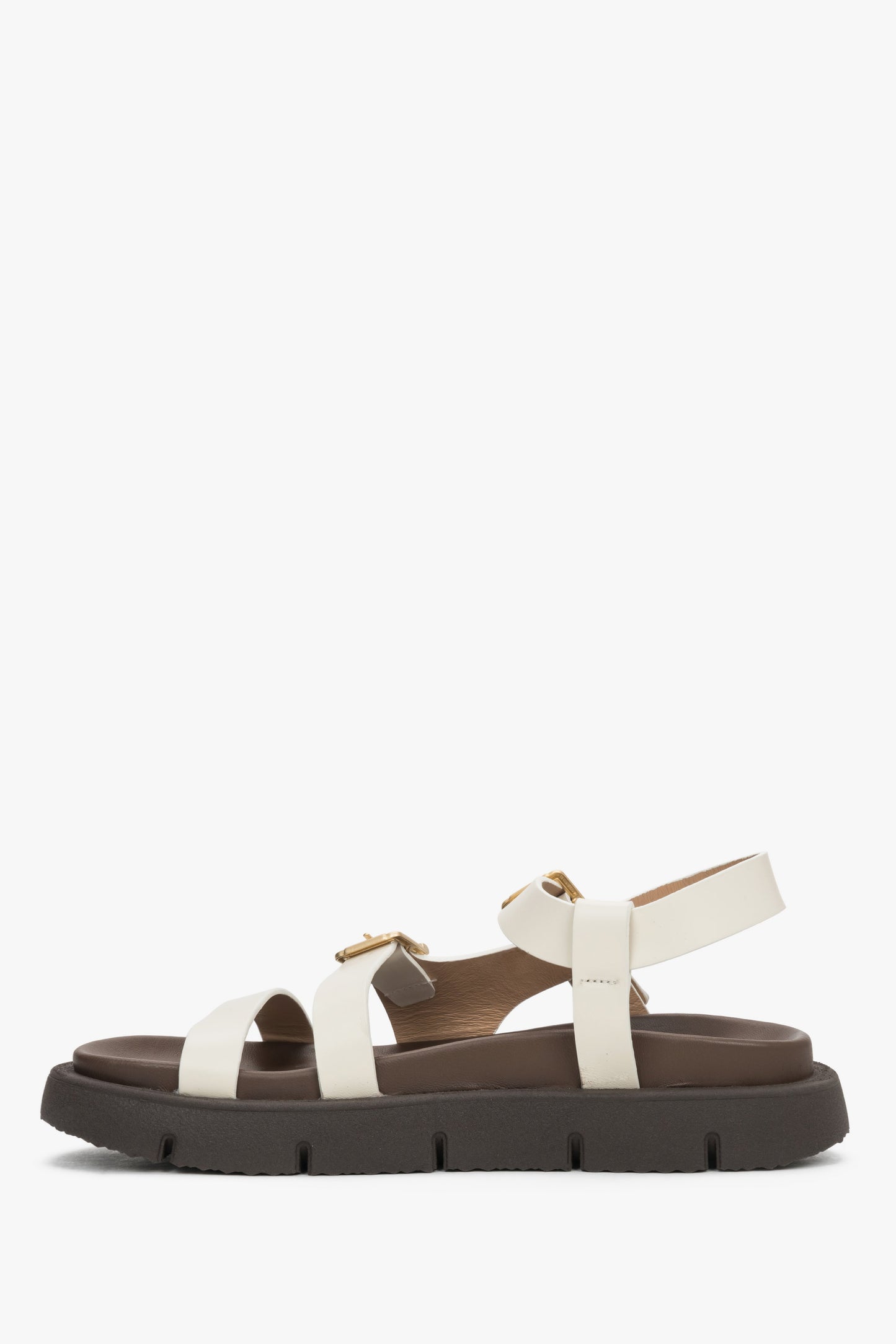 Milchbeige Damen-Sandale aus echtem Leder in seitlicher Profilansicht auf flacher Sohle
