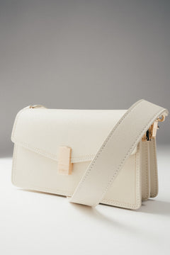 Frontalansicht der milchbeigen Damen-Schultertasche aus Leder mit goldenen Details.