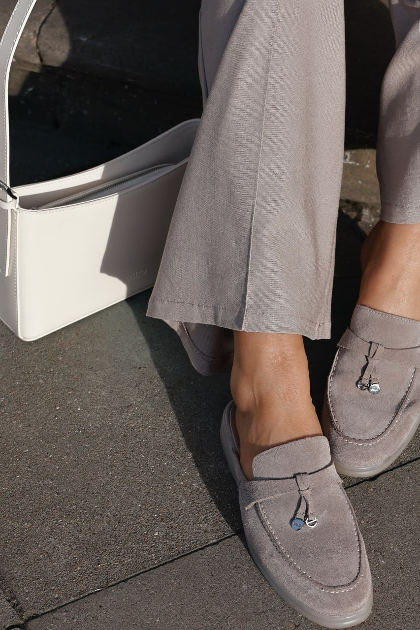 Milchbeige Damen-Schultertasche im Detail-Styling mit grauem Outfit und Mules