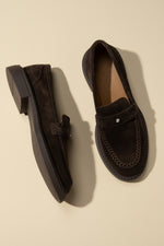 Draufsicht auf das Paar dunkelbrauner Penny-Loafer aus Velours in edlem Setting