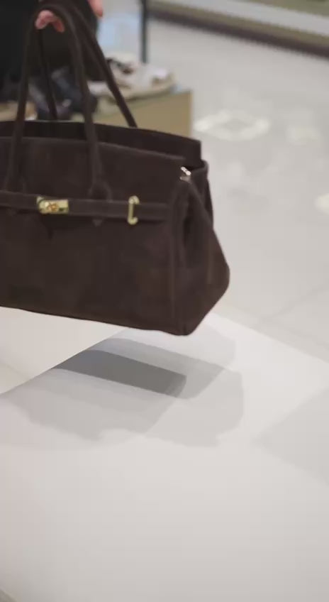 Präsentation der dunkelbraunen Velours-Henkeltasche in Bewegung