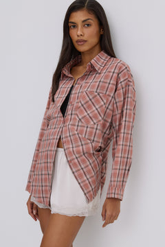 Seitenansicht des Models, das die lässige rosa Karo-Hemdbluse mit einer braunen Tasche kombiniert