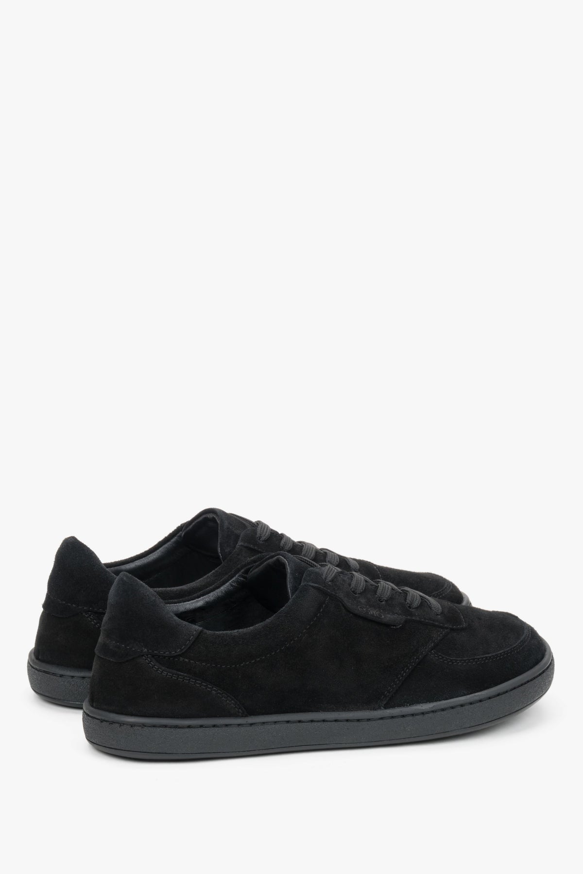 Schrägansicht des schwarzen Sneaker-Paares, die die anatomische Form und die Schnürung zeigt 