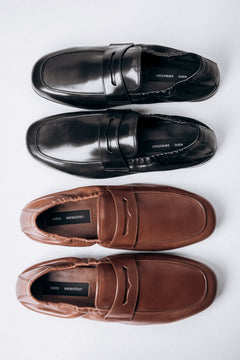 Elegante Anordnung der schwarzen und braunen Mokassins von Estro Selection.