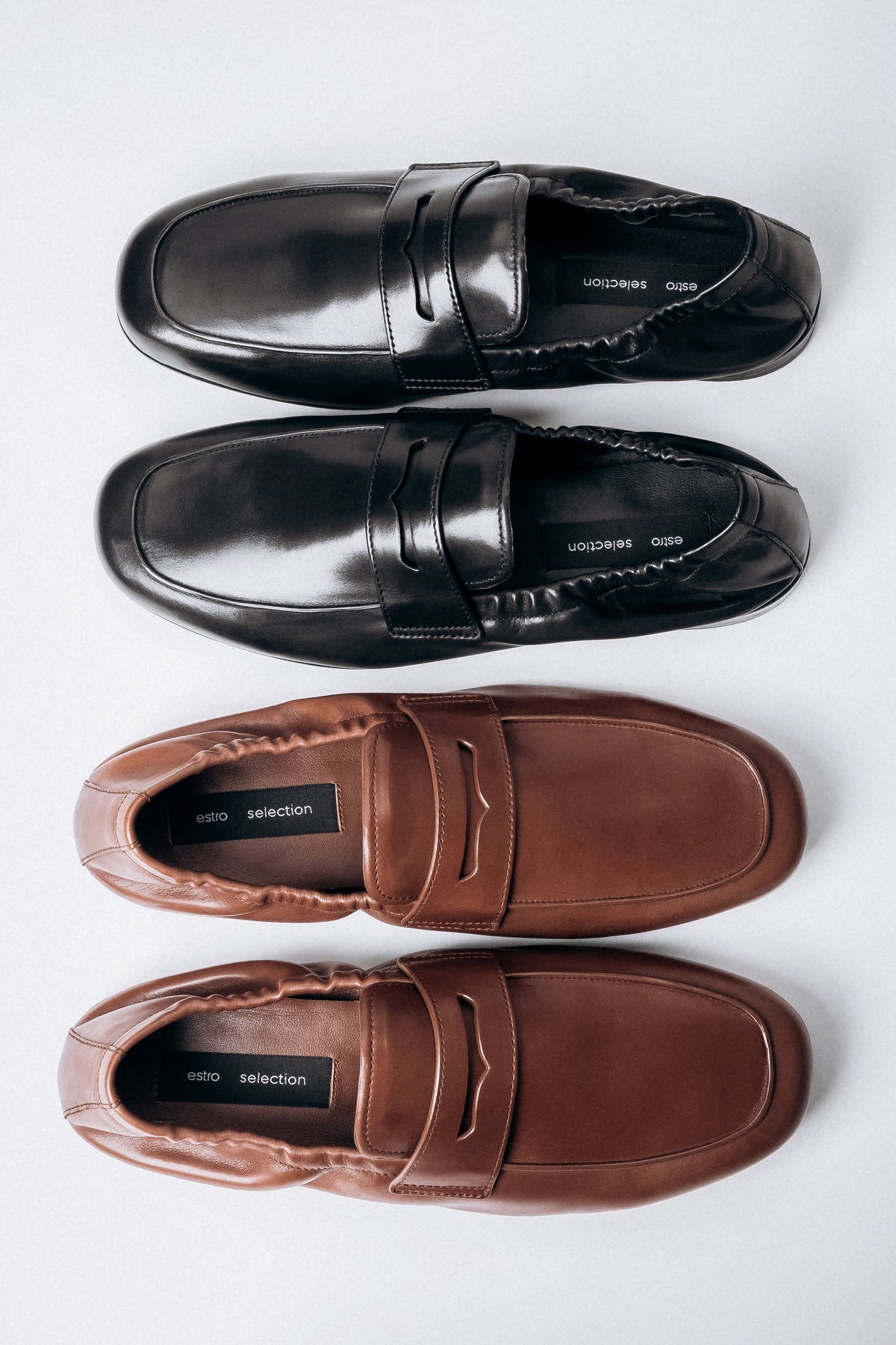 Elegante Anordnung der schwarzen und braunen Mokassins von Estro Selection.