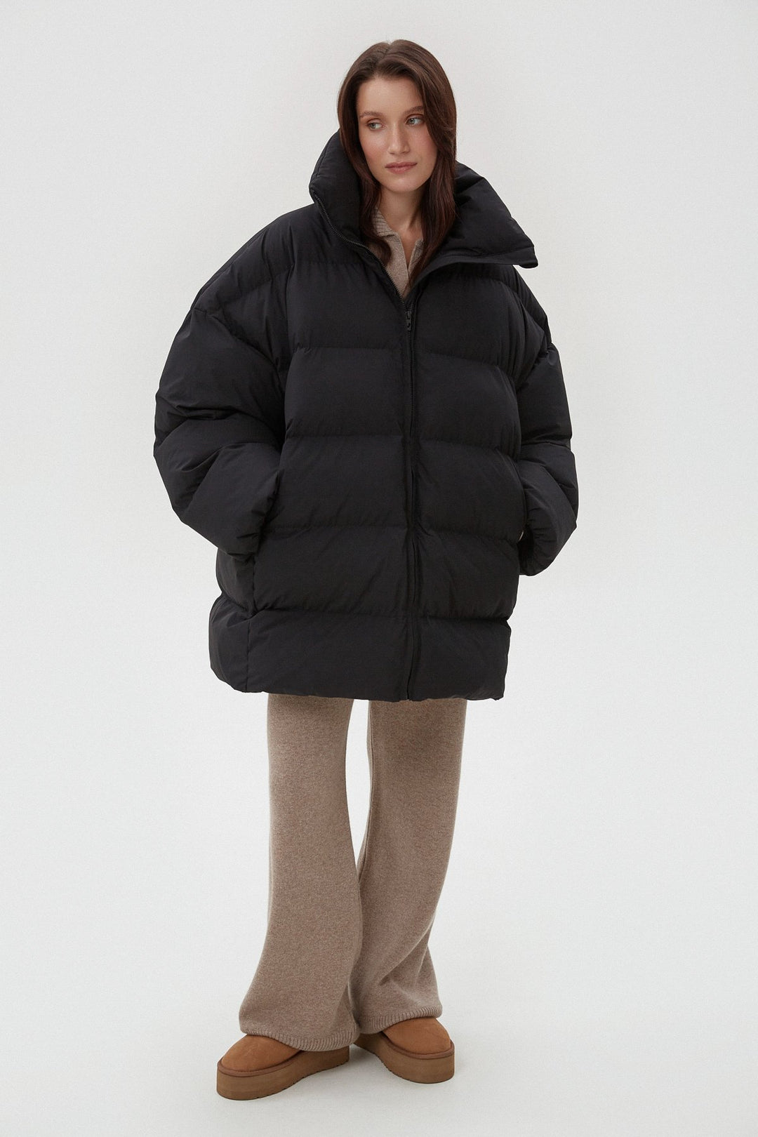 Ganztkörperansicht der Model in der schwarzen Daunenjacke mit weiter Hose