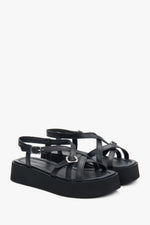 Schrägansicht des Paares schwarzer Plateau-Sandalen aus Leder mit überkreuzten Riemen