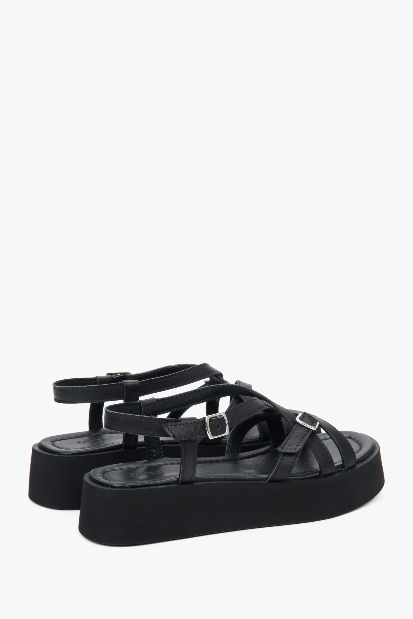 Rückansicht auf das Echtleder-Fußbett und die überkreuzten Riemen der schwarzen Sandalen