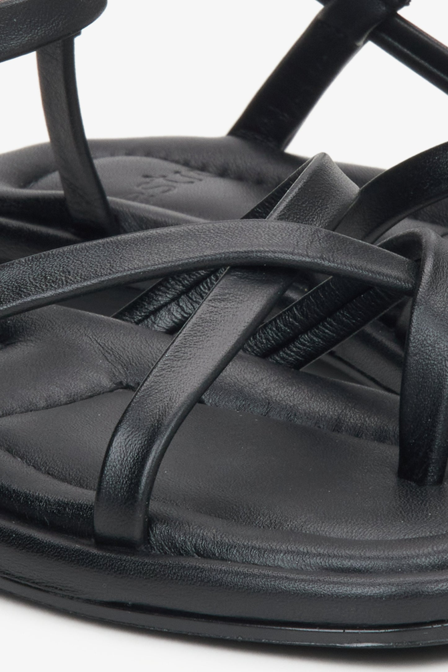 Detailaufnahme schwarzer Damen-Sandalen aus Leder mit gekreuzten Riemen