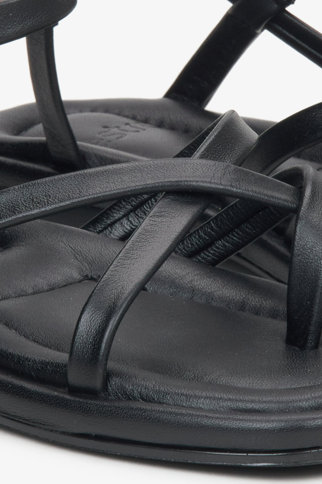 Detailaufnahme schwarzer Damen-Sandalen aus Leder mit gekreuzten Riemen