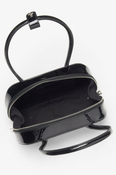 Eine Schultertasche aus schwarzem Lackleder, für Damen entworfen von Estro.