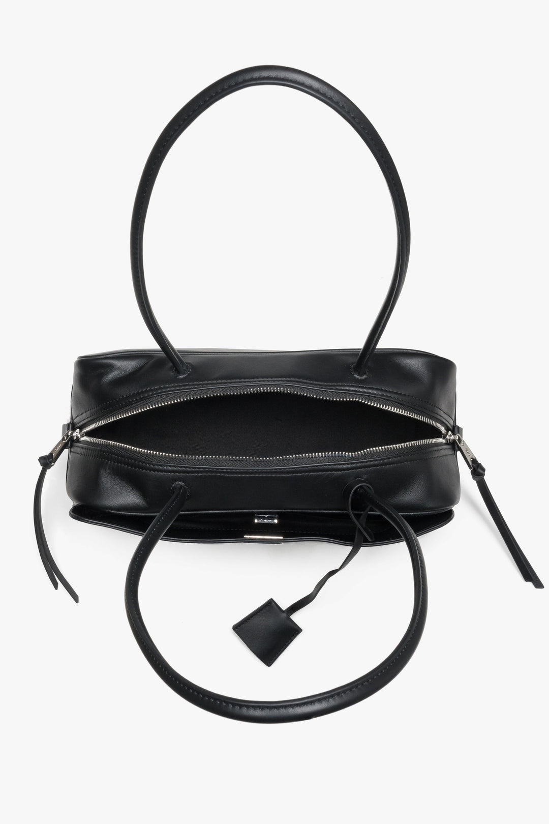 Detailansicht der Tasche von oben mit Fokus auf die zwei Reißverschlussfächer und Henkel.