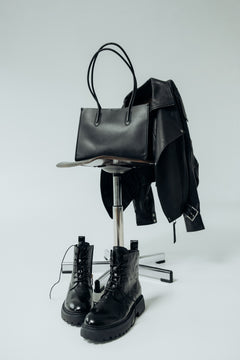 Atmosphärisches Lifestyle-Ensemble mit schwarzer Damen-Shopper-Tasche aus Echtleder, einer Lederjacke und passenden Schnürboots