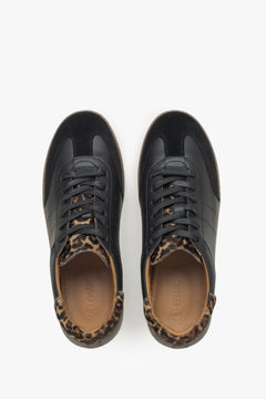 Symmetrische Draufsicht auf das Paar schwarzer Damen-Sneaker