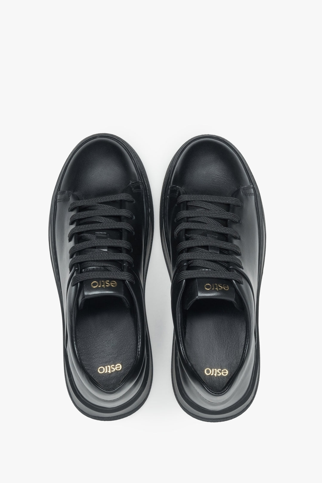 Draufsicht direkt von oben auf die schwarzen Sneaker und die klassische Schnürung