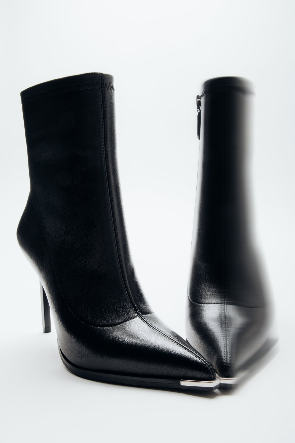 Schräge Frontalansicht der schwarzen Damen-Stiefeletten aus Echtleder auf weißem Hintergrund