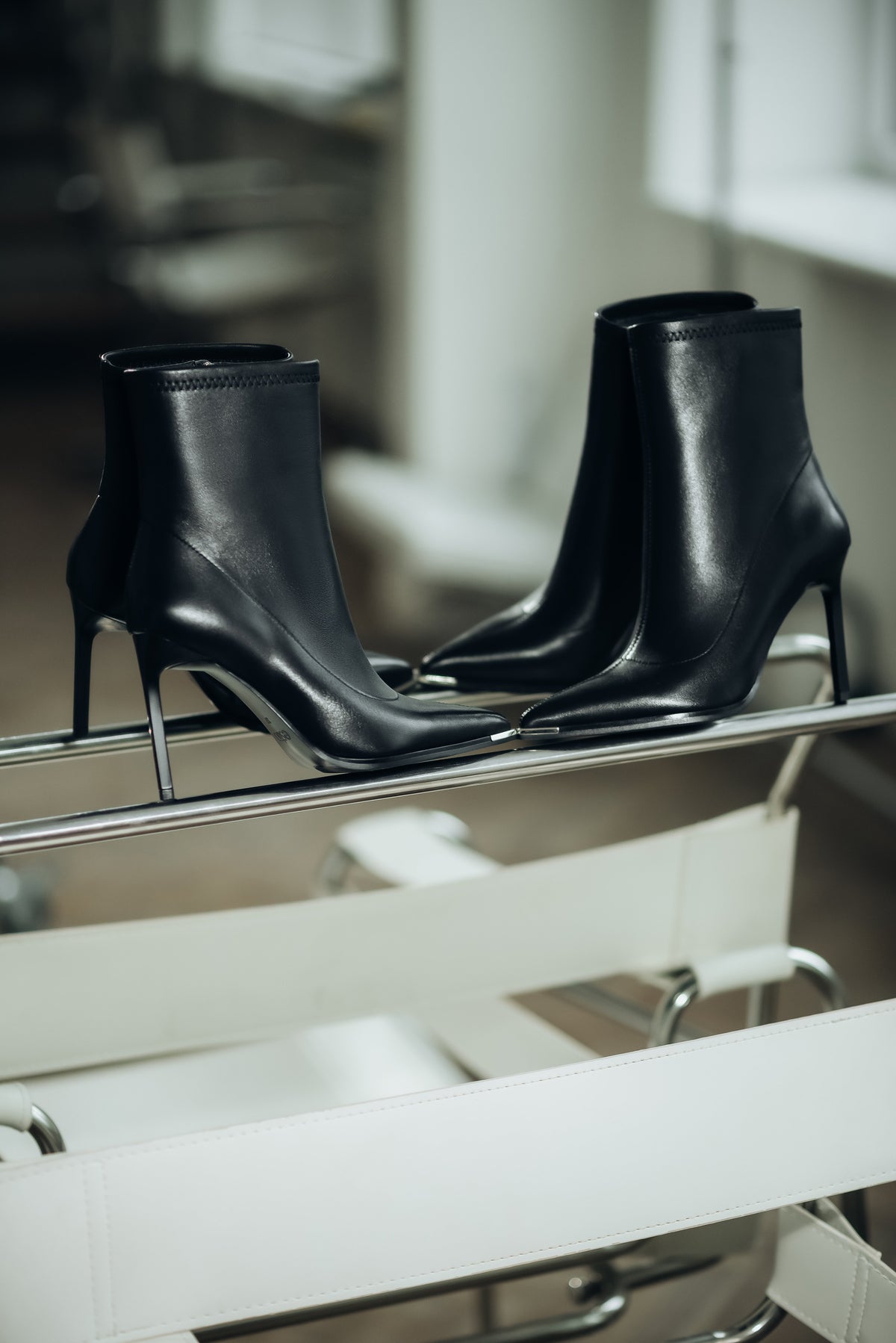 Seitliche Profilansicht der schwarzen Sock-Boots aus Leder mit hohem Pfennigabsatz und spitzer Zehenkappe