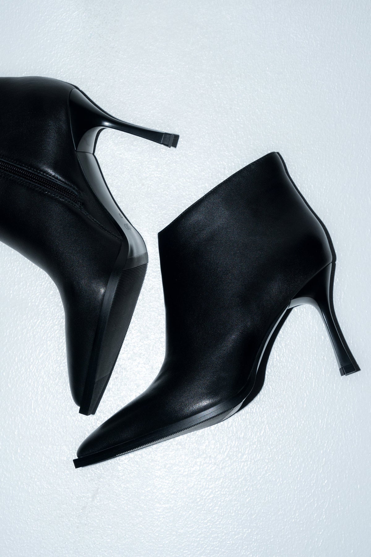 Künstlerische Draufsicht (Flatlay) der beiden Stiefel auf hellem Untergrund 