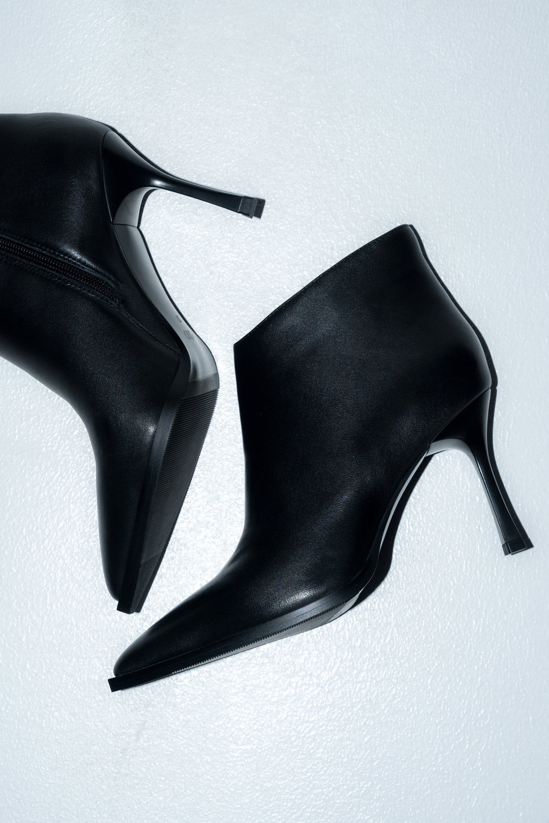 Künstlerische Draufsicht (Flatlay) der beiden Stiefel auf hellem Untergrund 