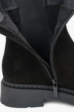 Detailaufnahme des geöffneten Reißverschlusses an der Innenseite der schwarzen Stiefeletten