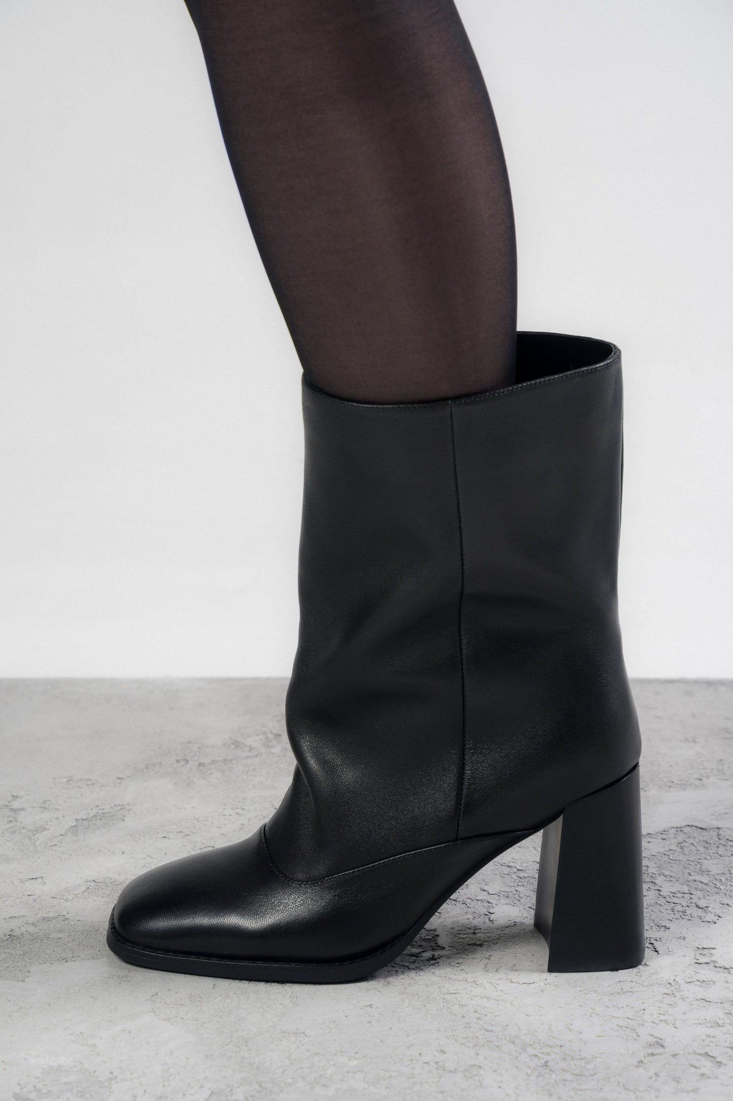 Modelansicht der getragenen schwarzen Leder-Stiefelette am Bein zur Demonstration der lockeren Passform