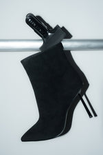 Inszenierte Darstellung der schwarzen Damen-Stiefelette aus Velours auf einer silbernen Stange 