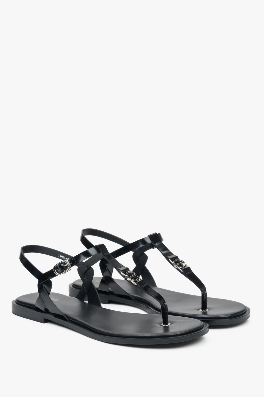 Schrägansicht des Paares schwarzer Leder-Sandalen mit feinem Fesselriemchen und silbernen Details