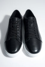 Draufsicht auf das Paar schwarzer Herren-Sneaker aus weichem Echtleder.