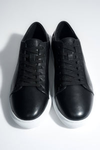 Draufsicht auf das Paar schwarzer Herren-Sneaker aus weichem Echtleder.