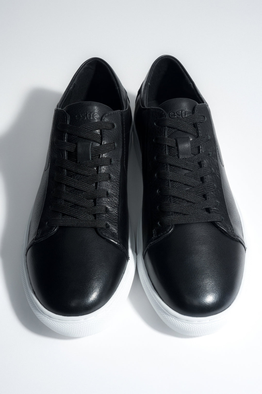 Draufsicht auf das Paar schwarzer Herren-Sneaker aus weichem Echtleder.