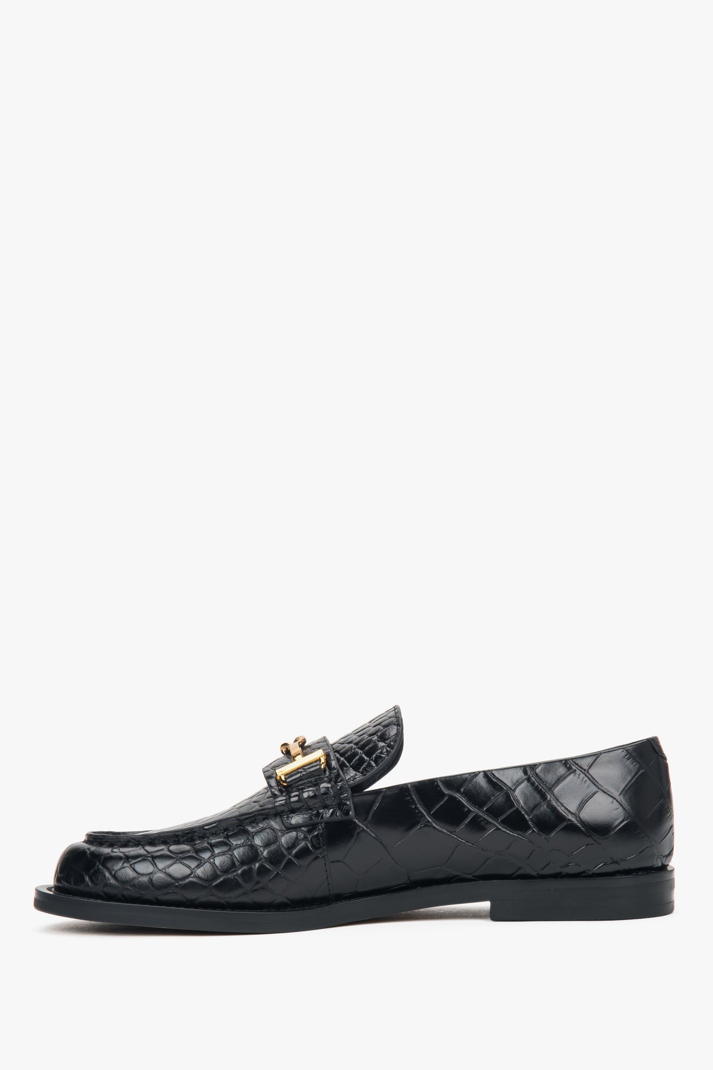 Klassische schwarze Slipper aus Glattleder mit dekorativem Metallelement. 