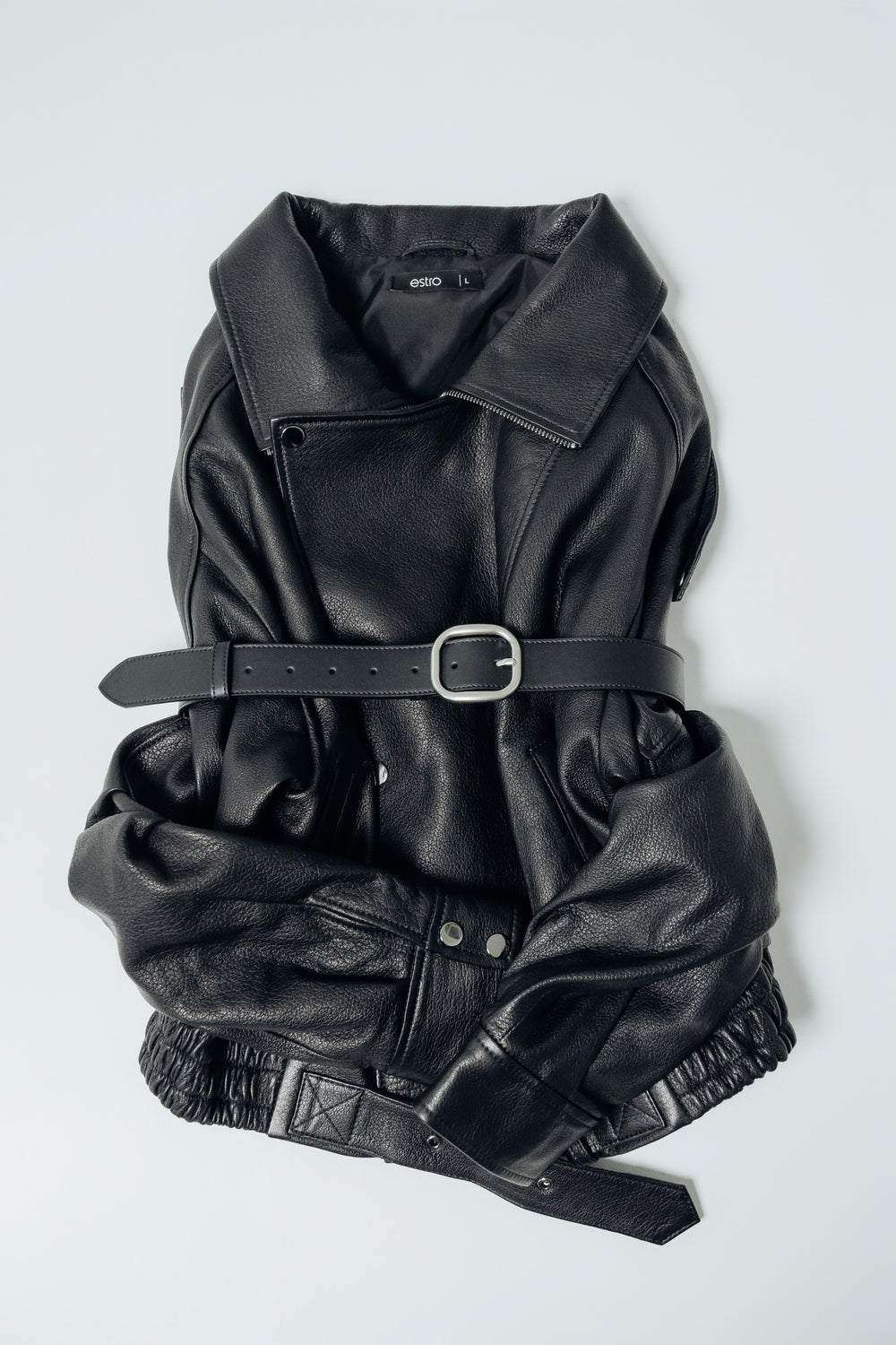 Schwarzer Damen-Ledergürtel, raffiniert um eine schwarze Lederjacke gebunden
