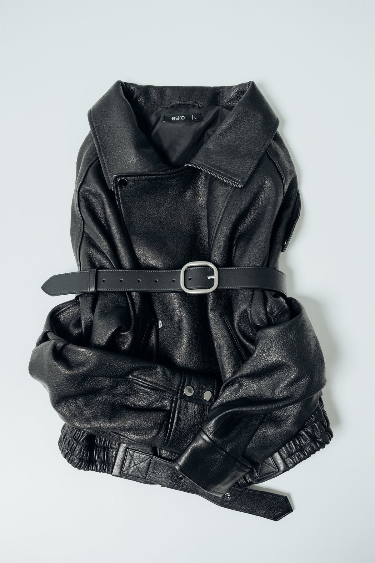 Schwarzer Damen-Ledergürtel, raffiniert um eine schwarze Lederjacke gebunden