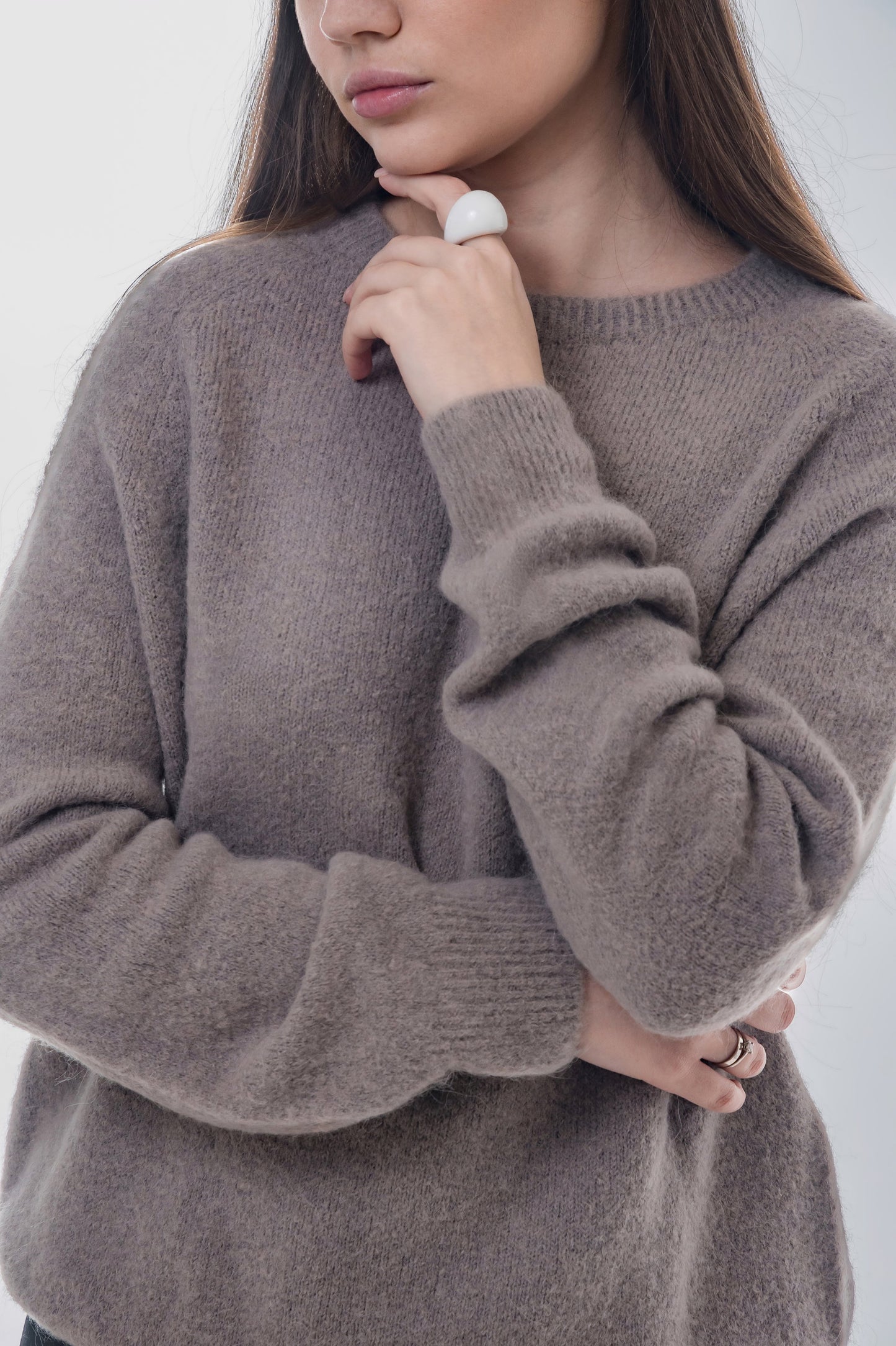 Halbprofil-Ansicht des Models zur Veranschaulichung der eleganten Strickstruktur und Passform 