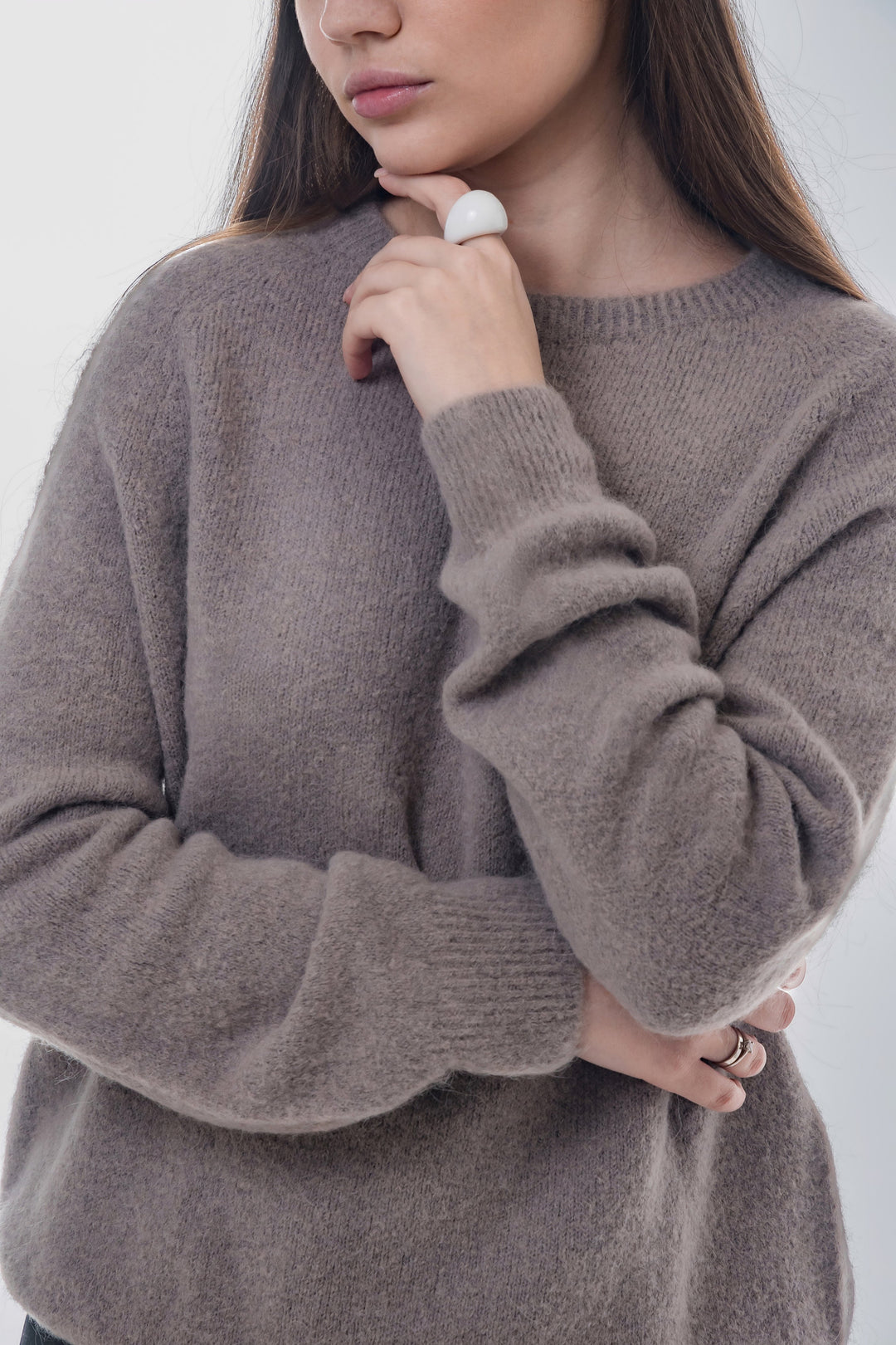 Halbprofil-Ansicht des Models zur Veranschaulichung der eleganten Strickstruktur und Passform 