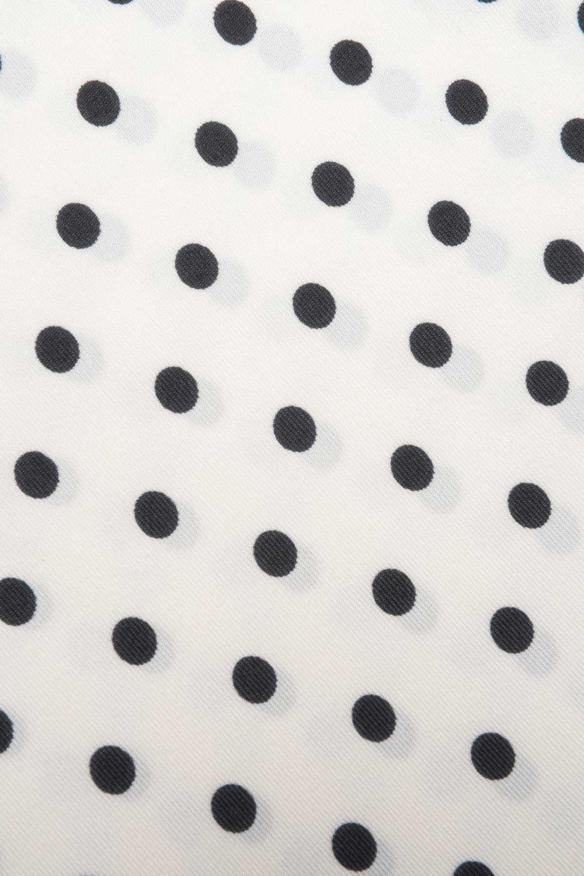 Detailaufnahme des feinen Stoffes und des zeitlosen weiß-schwarzen Polka-Dot-Musters