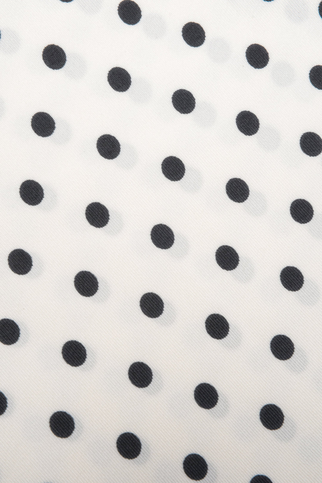 Detailaufnahme des feinen Stoffes und des zeitlosen weiß-schwarzen Polka-Dot-Musters