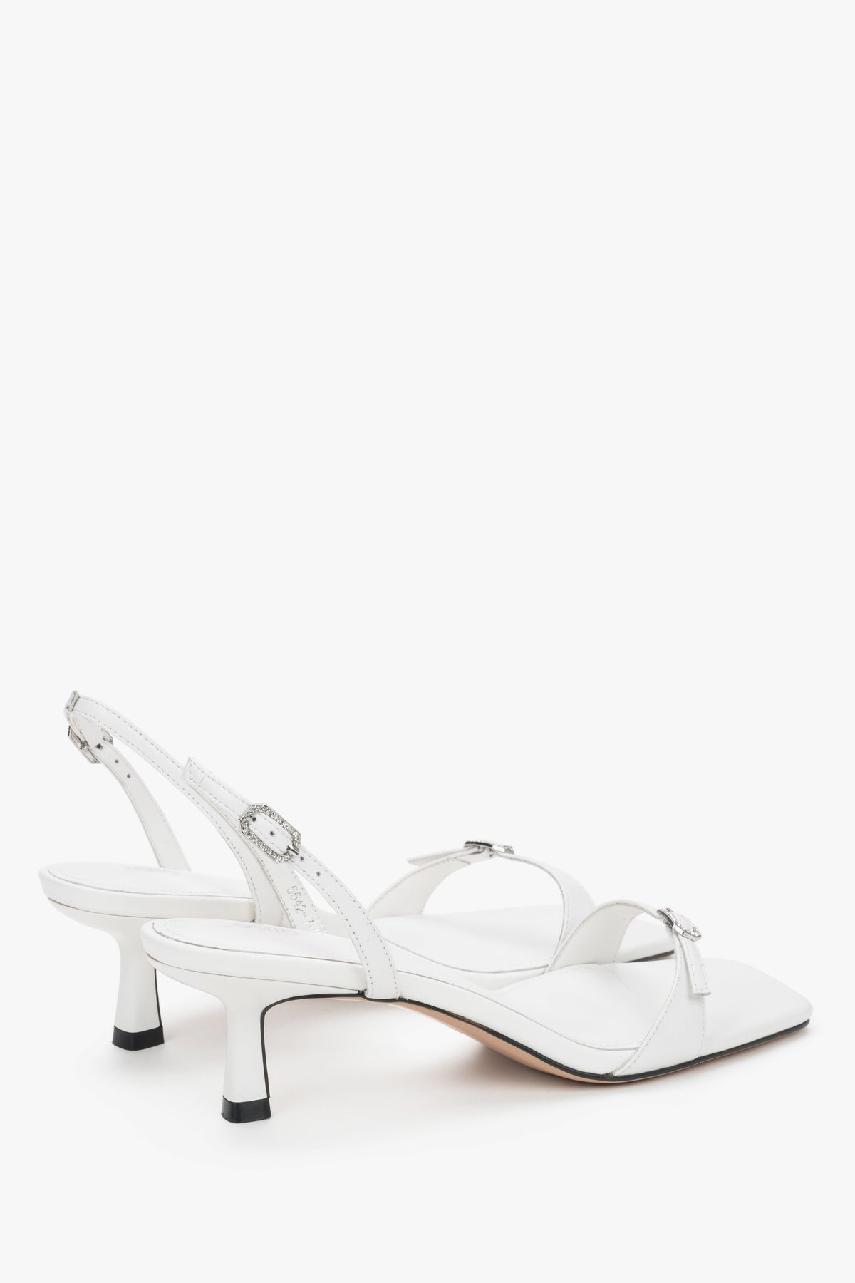 Rückansicht der eleganten weißen Ledersandalen mit verstellbarer Schnalle.