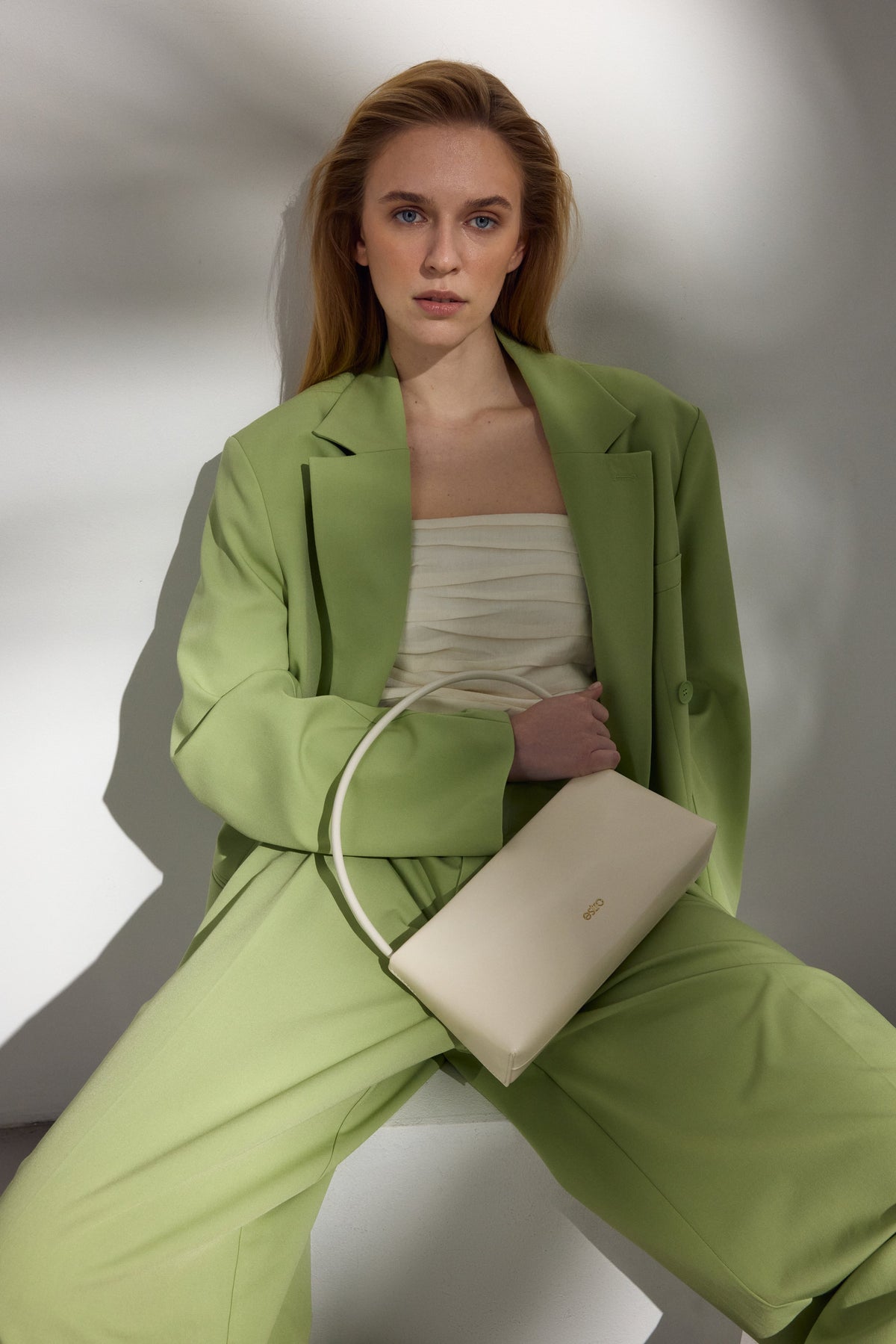 Weiße Damen-Schultertasche aus Leder getragen von einem Model.