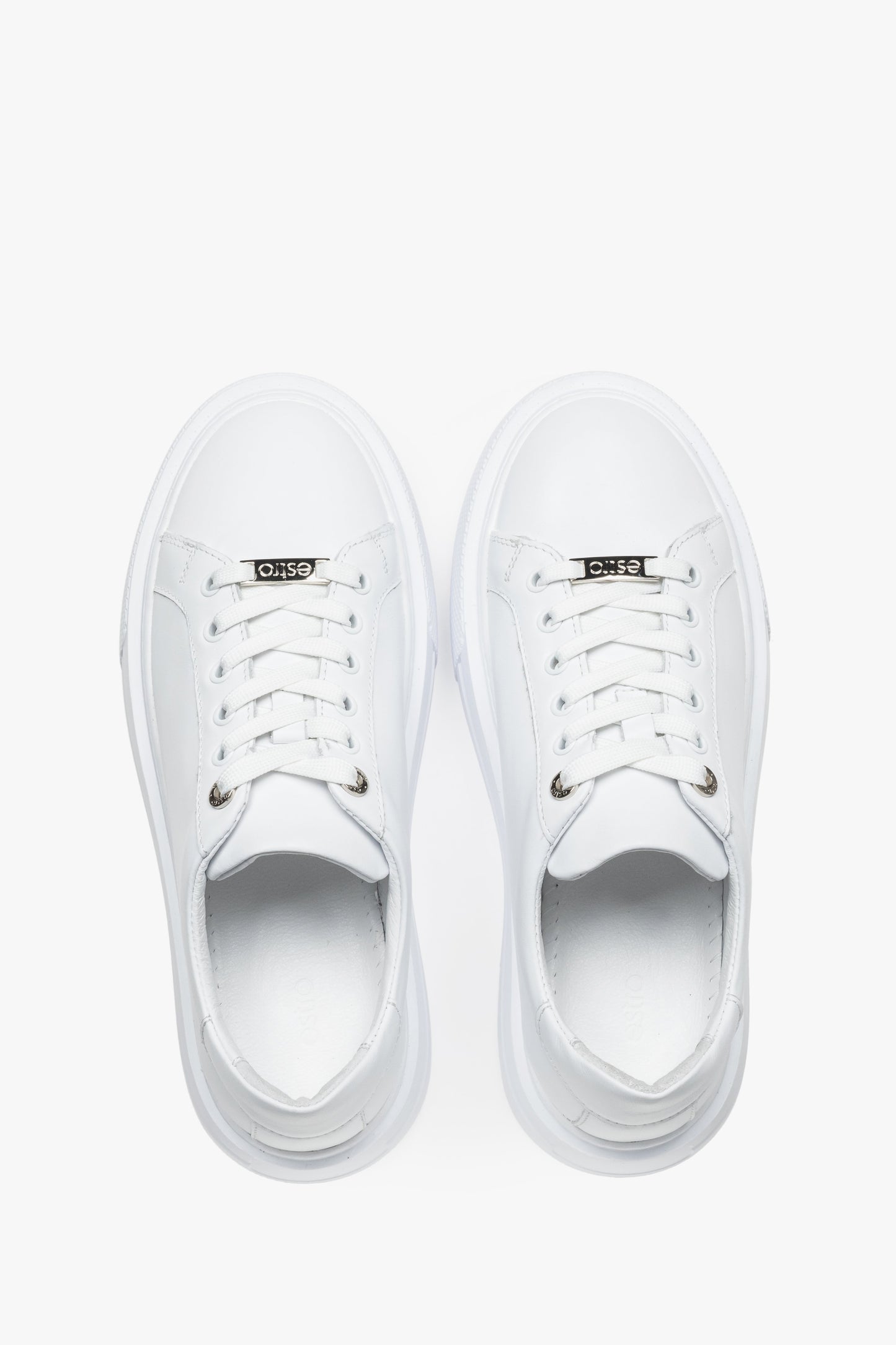 Draufsicht auf das Paar weißer Damen-Sneaker mit Schnürung.