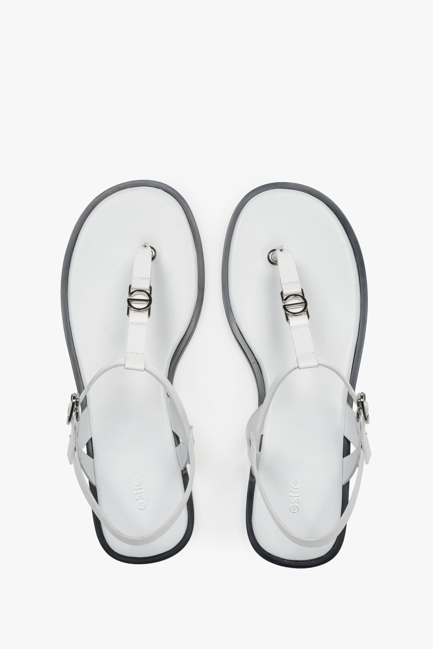 Draufsicht auf die weißen Zehentrenner-Sandalen aus Leder mit silbernen Details und dunkler Sohlenkante