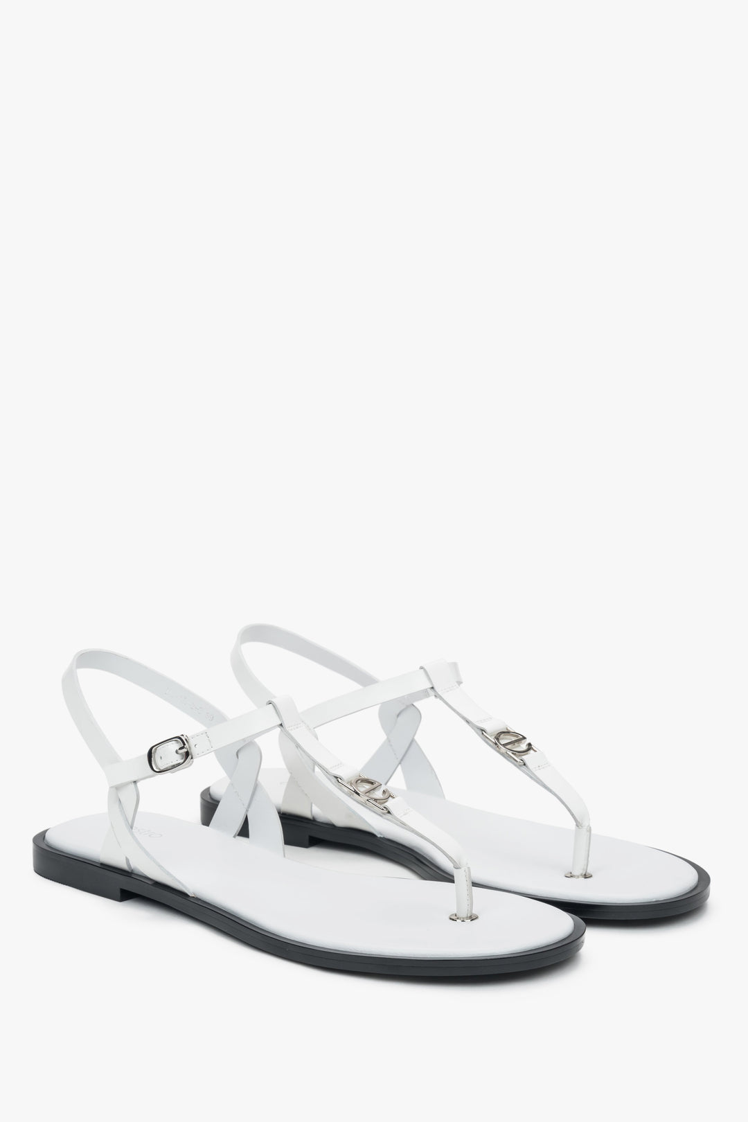 Schrägansicht des Paares weißer Leder-Sandalen mit feinem Fesselriemchen