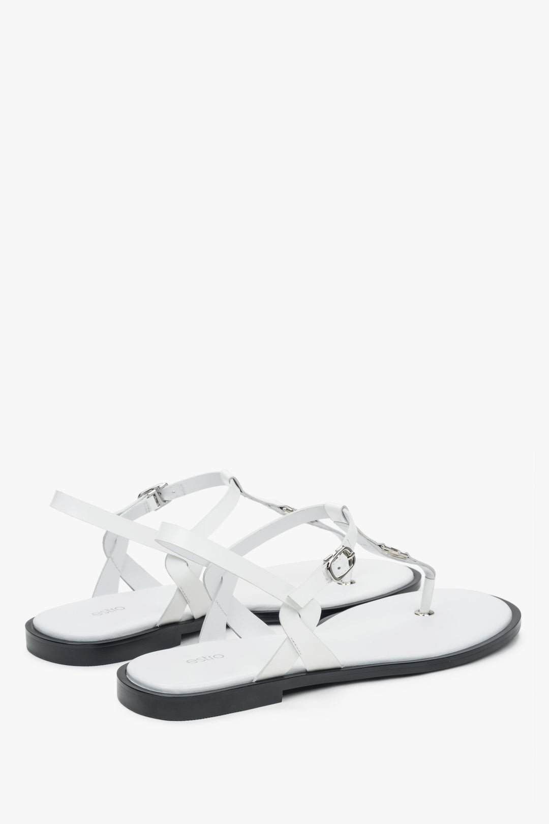 Rückwärtige Schrägansicht der weißen Sommer-Sandalen mit Fokus auf die flache Sohle