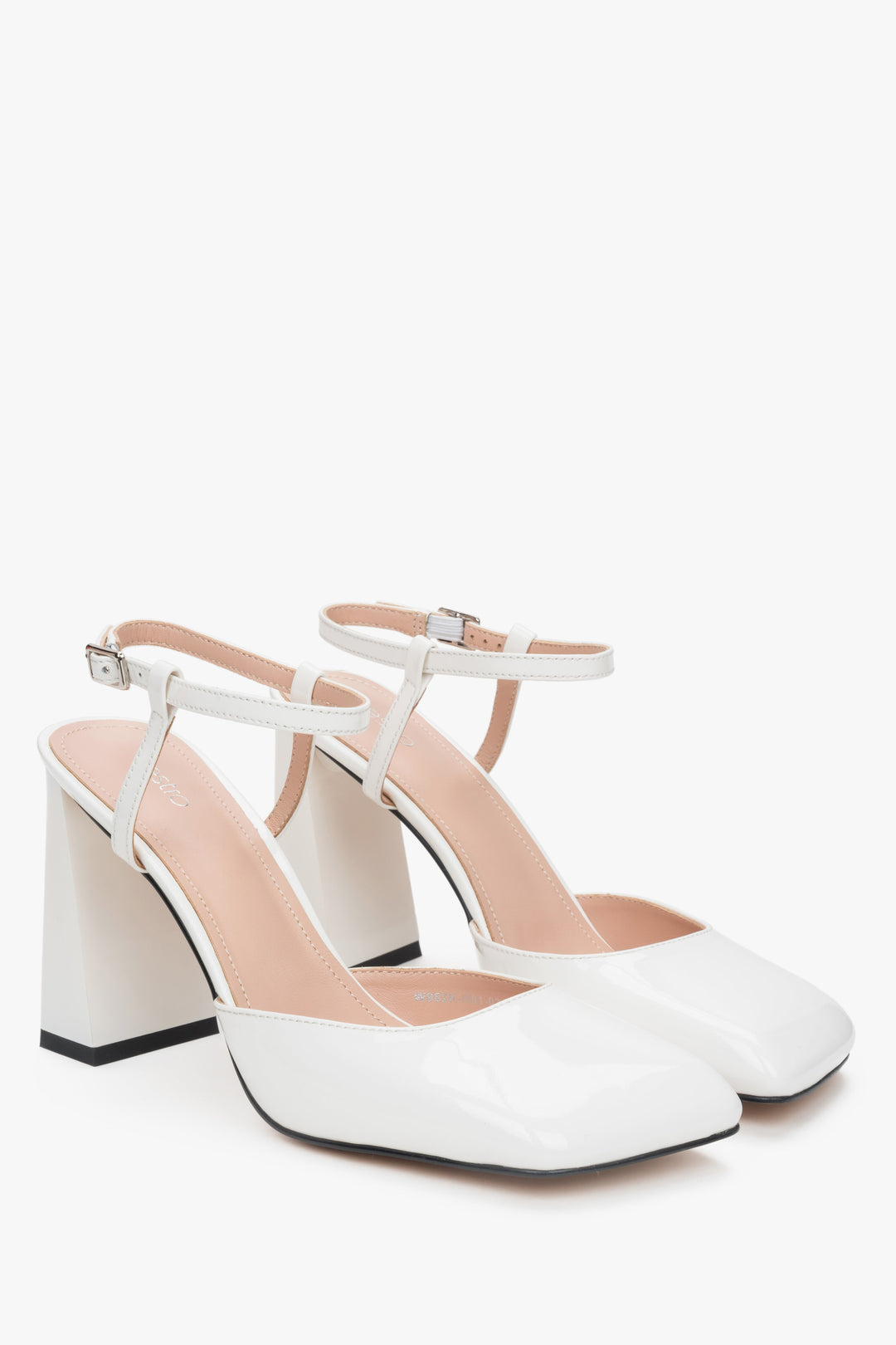 Schrägansicht des Paares eleganter weißer Damen-Sandaletten aus glänzendem Lackleder