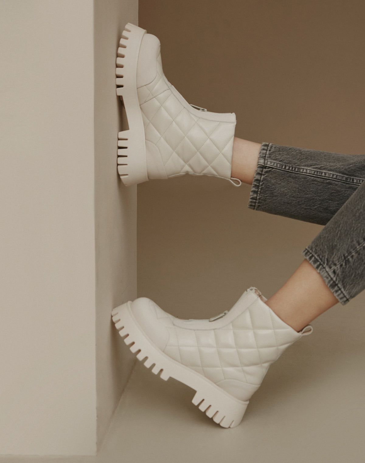 Weiße gesteppte Damen-Winterstiefeletten – Präsentation des Schuhwerks am Modell.